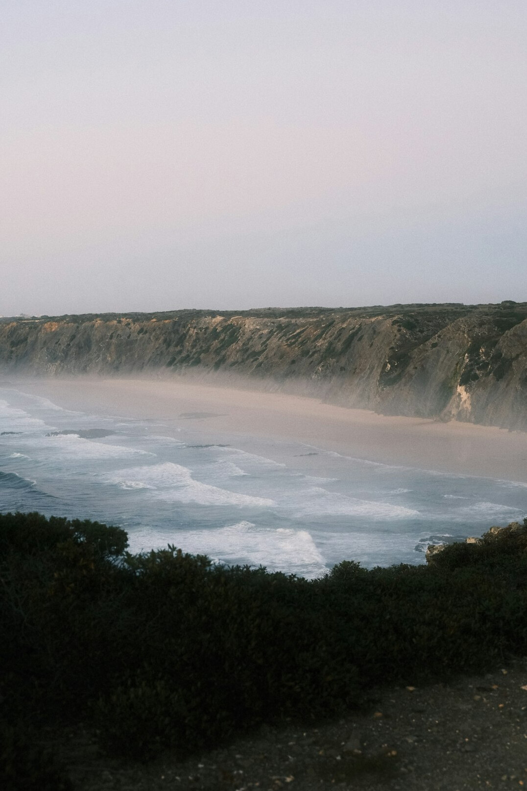 Empty infinity pool overlooking the Atlantic Ocean at dusk